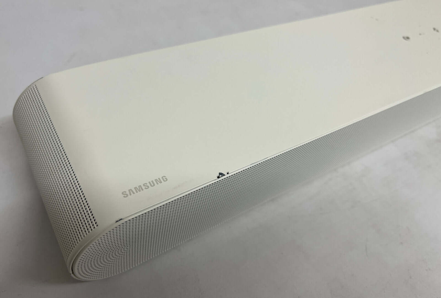 Close-up of SAMSUNG HW-S61B soundbar showing sleek white design and brand logo.