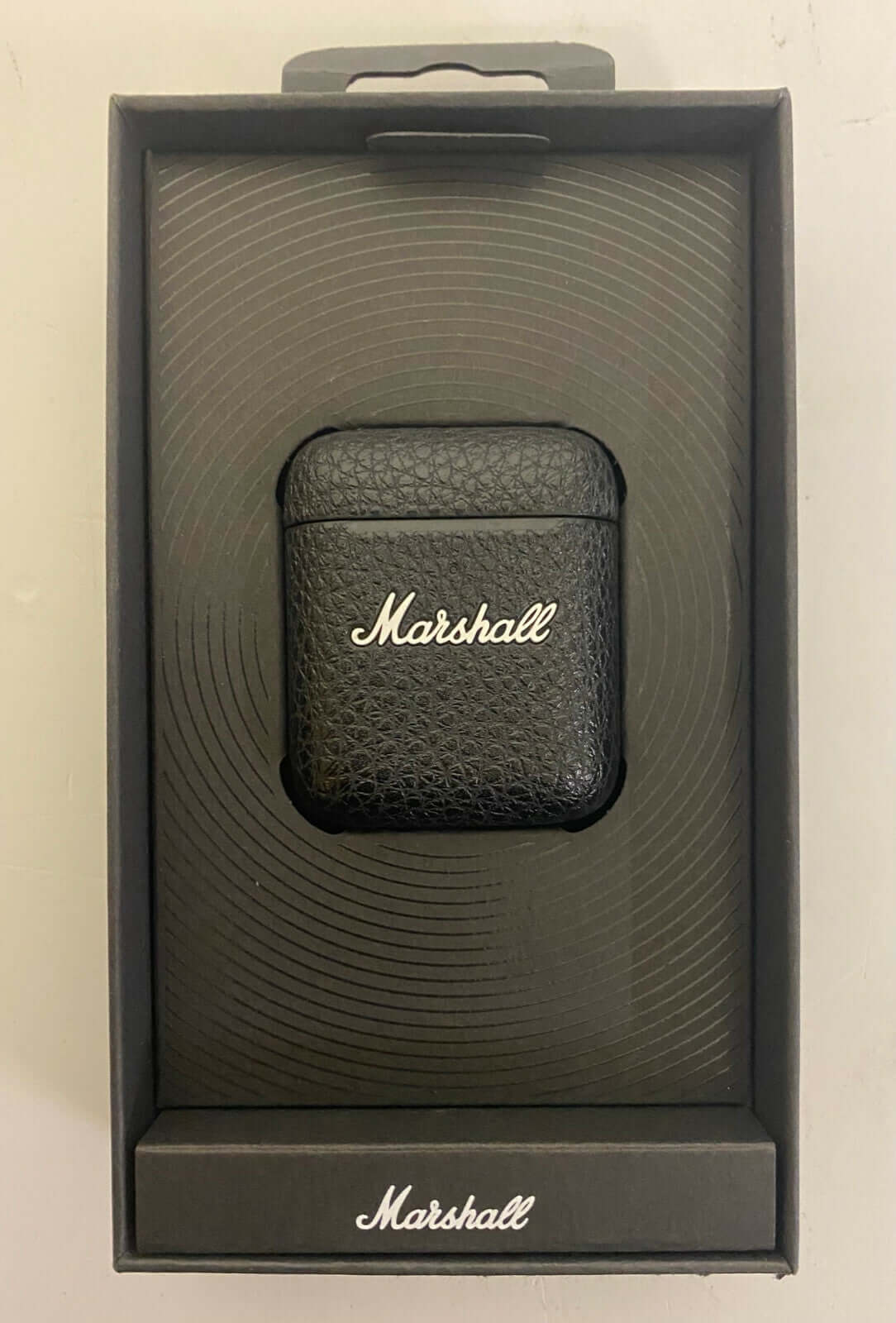 Marshall Minor III Bluetooth earphone charging case in black packaging, showcasing a sleek design and logo.
