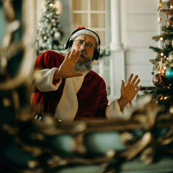 Perfect Christmas Tech Gifts from Electrical Bargain Ltd🎄: Santa enjoying music with headphones near a holiday tree.