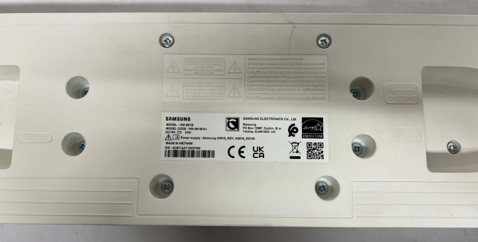 Bottom view of SAMSUNG HW-S61B soundbar showing labels, connectors, and mounting holes.