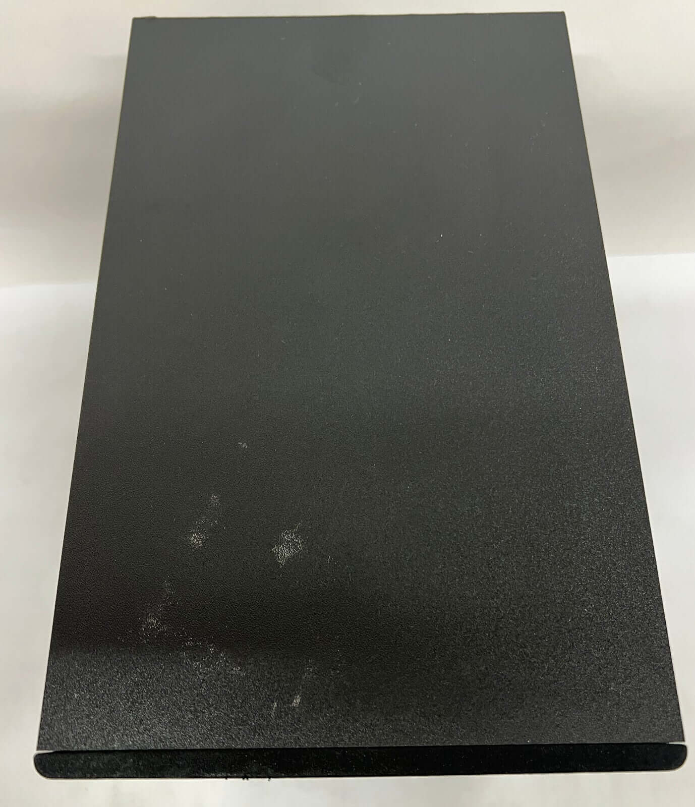 Black metal object with a smooth finish, viewed from above, showcasing a minimalist design.