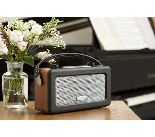 ROBERTS VINTAGE PORTABLE RETRO DAB FM DIGITAL RADIO MAINS/BATTERY LCD DISPLAY on a wooden table with flowers.