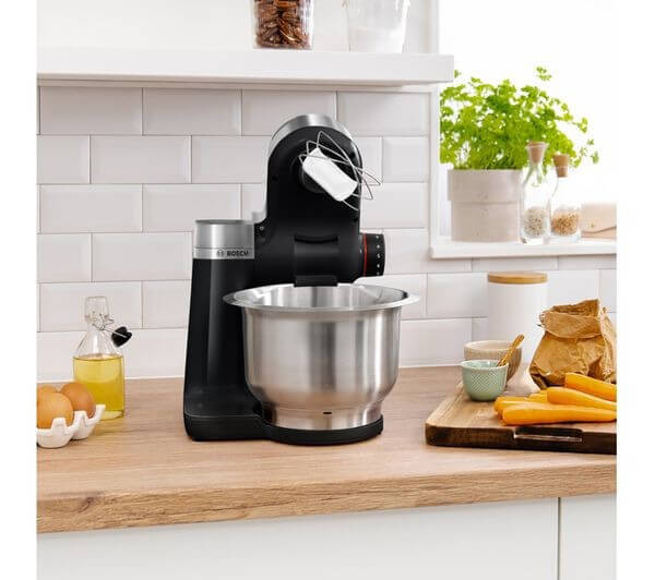 BOSCH 7-IN-1 MUMS2VM40 KITCHEN MACHINE STAND MIXER 900W 3.8L 7 SPEED BLACK NEW on kitchen counter with various ingredients.