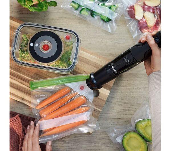 BOSCH SERIES 4 ErgoMaster MSM4B6V2GB HAND BLENDER VARIABLE SPEED 1000W BLACK in use with vegetables and storage bags.