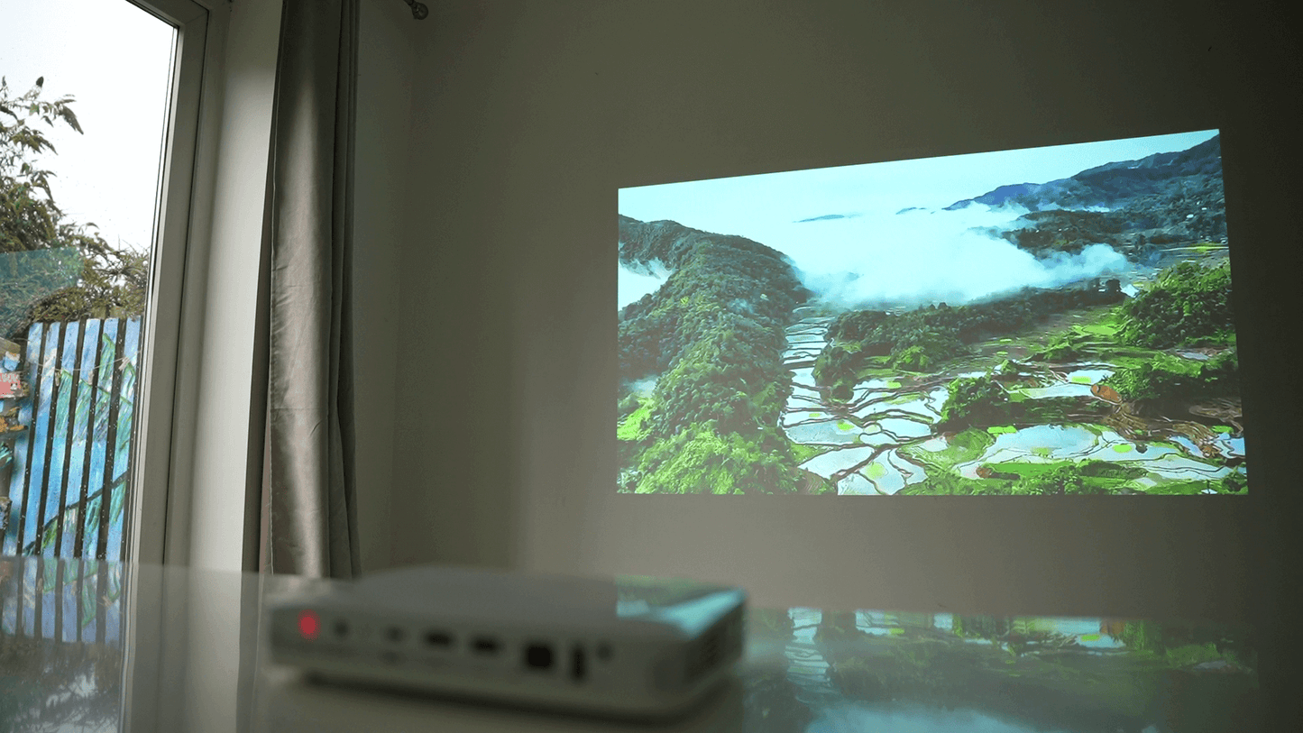 Pico Genie M550 Plus 4.0 Smart Projector projecting a scenic landscape onto a wall.