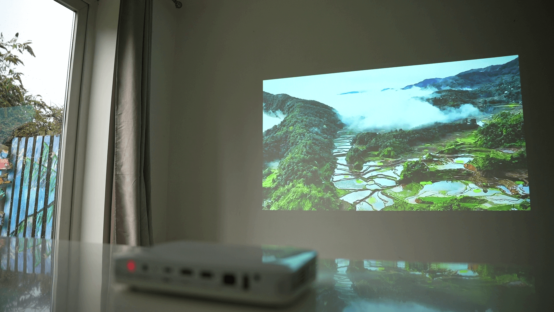 Pico Genie M550 Plus 4.0 Smart Projector projecting a scenic landscape onto a wall.