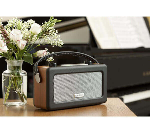 ROBERTS VINTAGE PORTABLE RETRO DAB FM DIGITAL RADIO MAINS/BATTERY LCD DISPLAY on a wooden table with flowers.